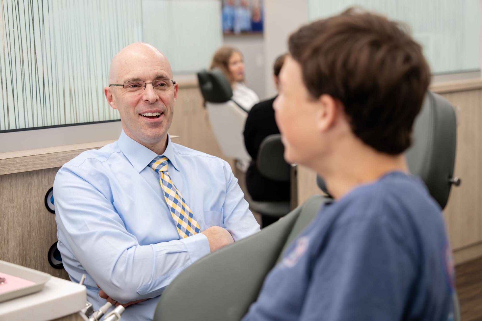 orthodontist springfield il-002 Orthodontist consulting with a young patient in a modern orthodontic office, emphasizing personalized care and family-friendly atmosphere in Springfield, IL.
